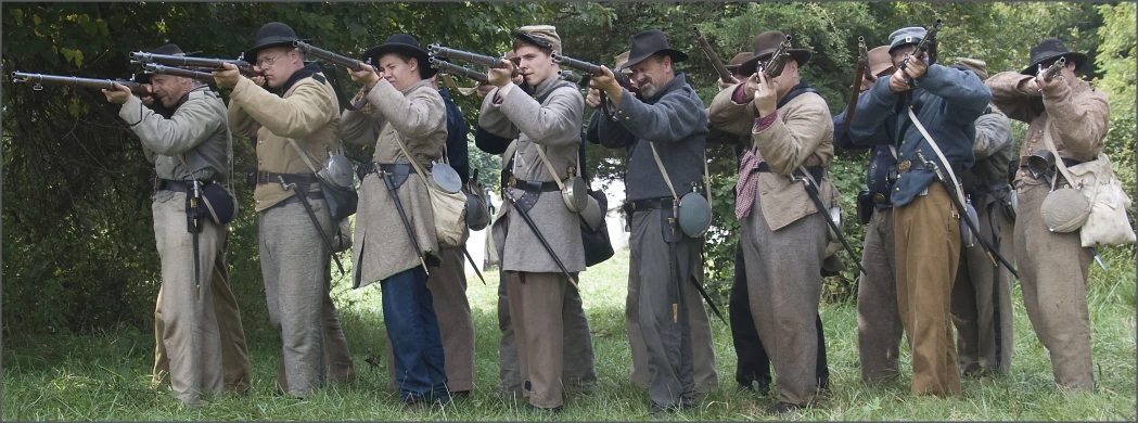 some guys holding onto hats and guns in the woods