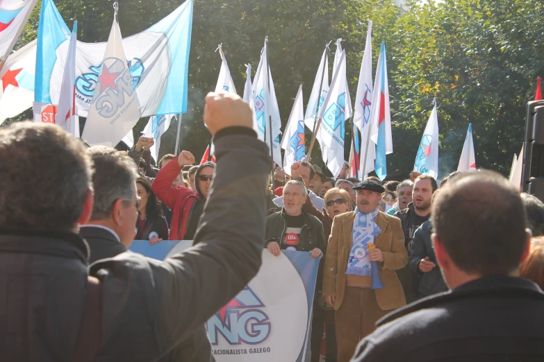 a man is holding up a flag in a crowd