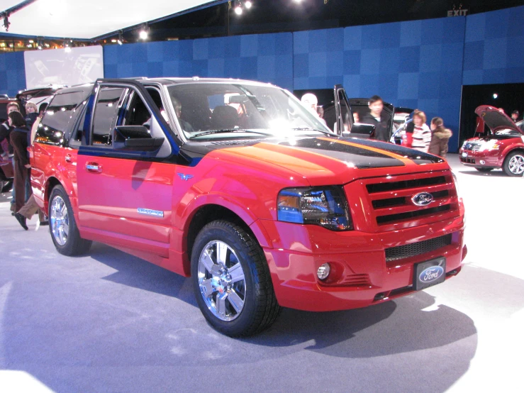 a red pickup truck sitting on top of a show floor