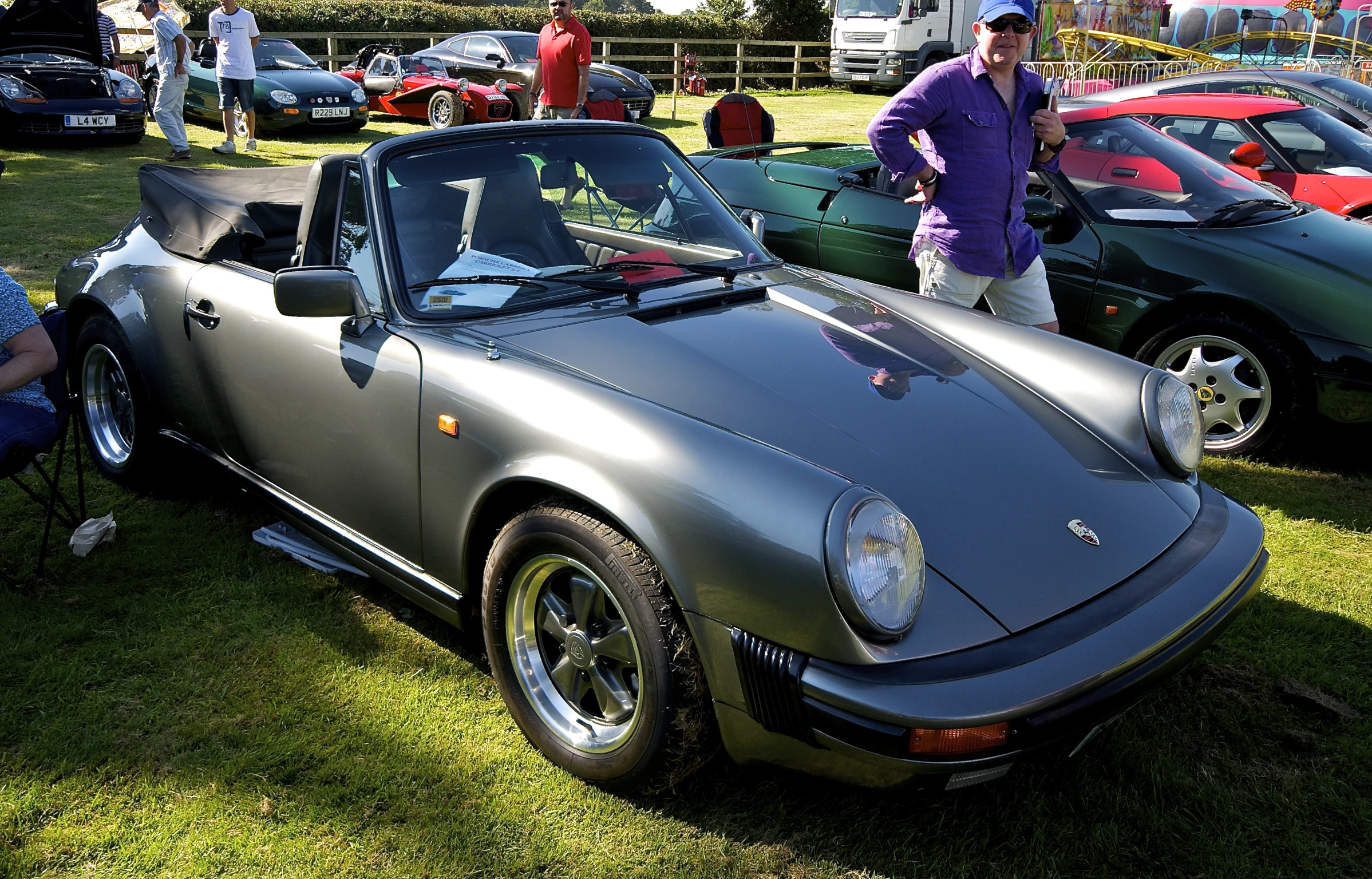 a woman in purple standing next to a porsche