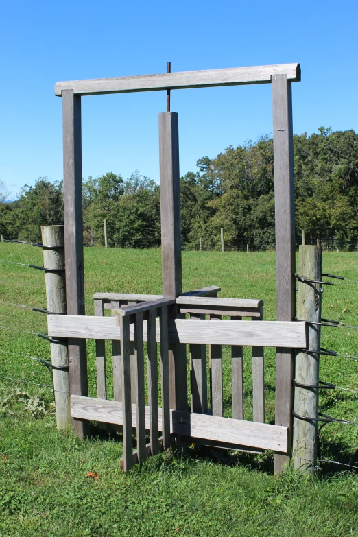 a wooden park bench sitting on top of a green field