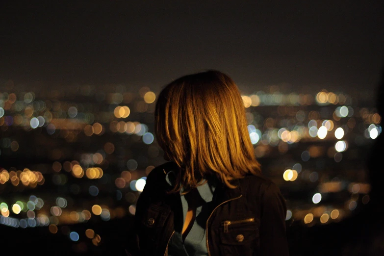 a woman standing in front of a night city