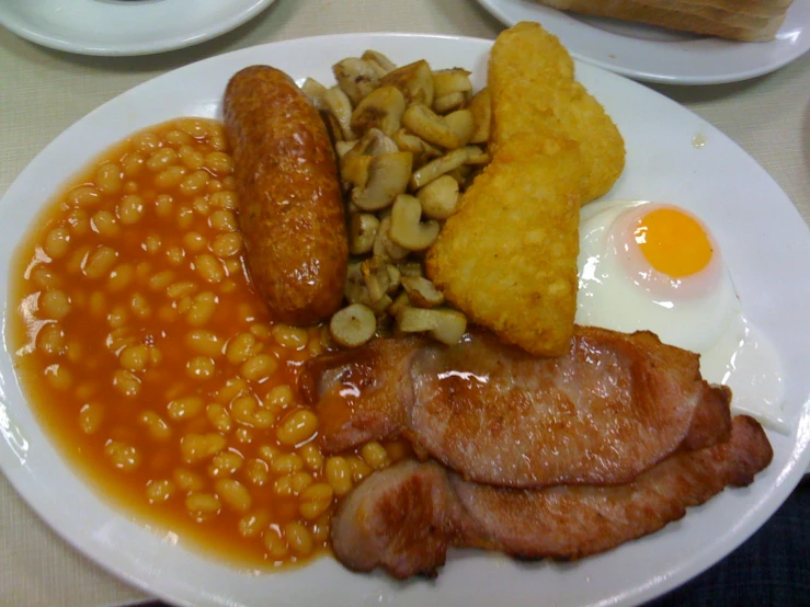 the breakfast plate is full of eggs, bacon and beans