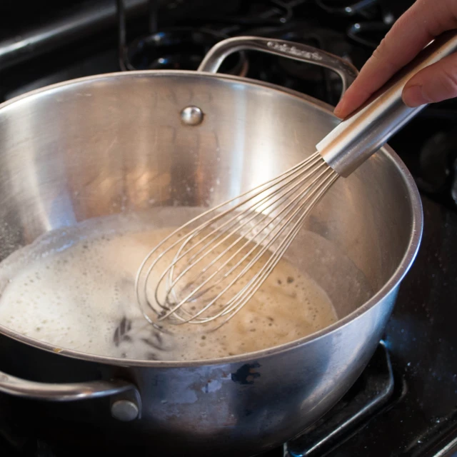 a hand that is stirring soing into some water