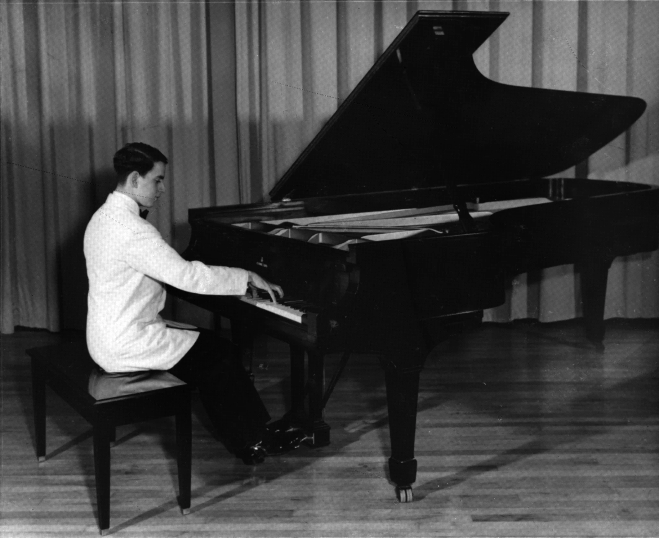 a man playing piano in an old fashion room