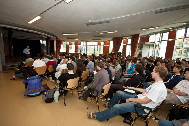 a crowd of people sitting around a room