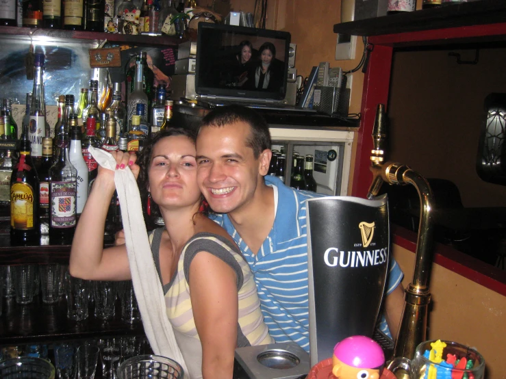 two people sitting at a bar, one holding up a banana