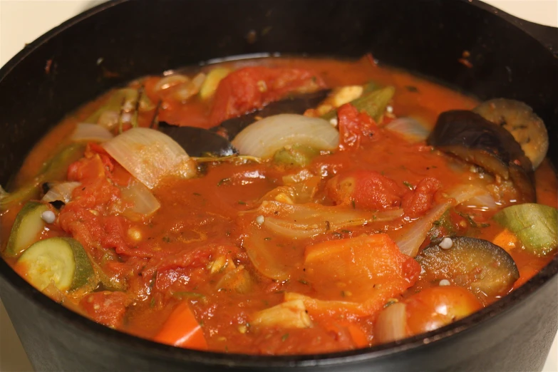 a pot filled with vegetables and sauce on the stove