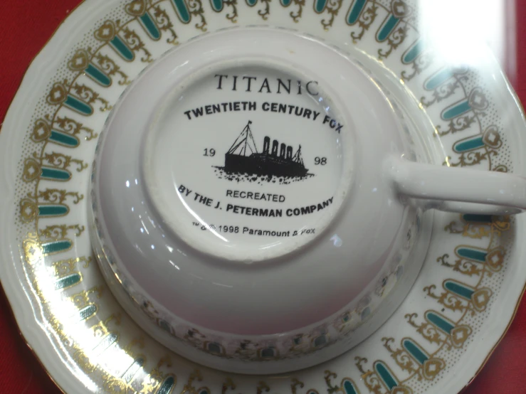 this cup has a saucer on it with a boat on it