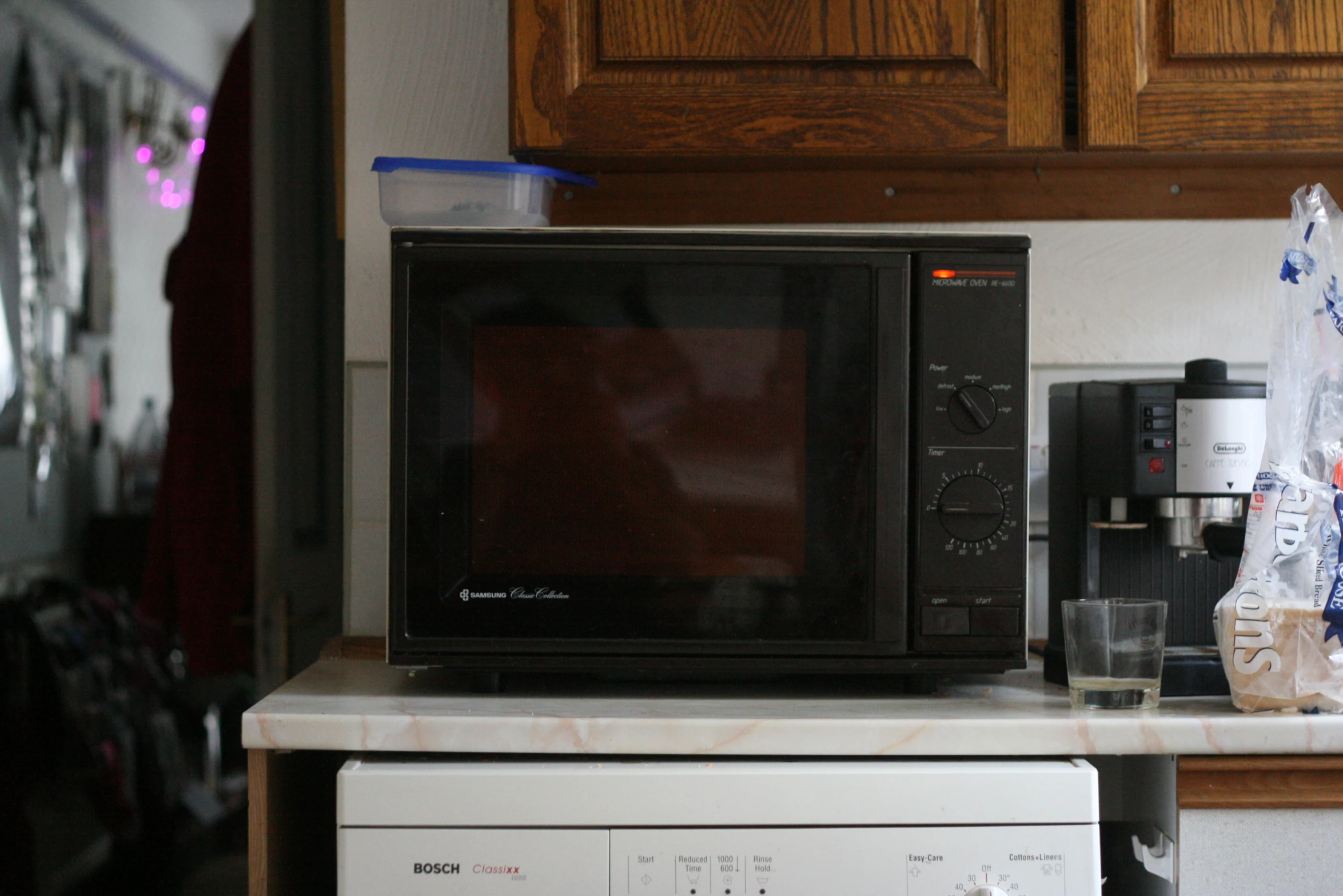 a black microwave on a counter next to a blender and microwave oven