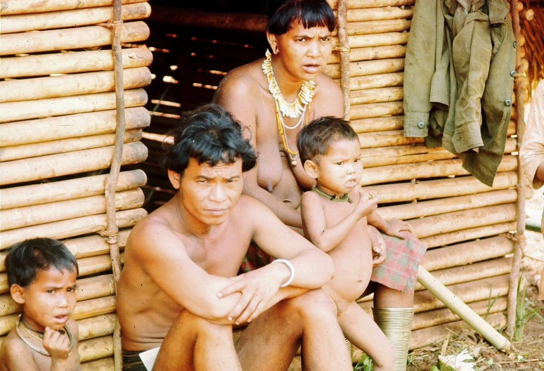 a group of s and adults with small children outside of a building