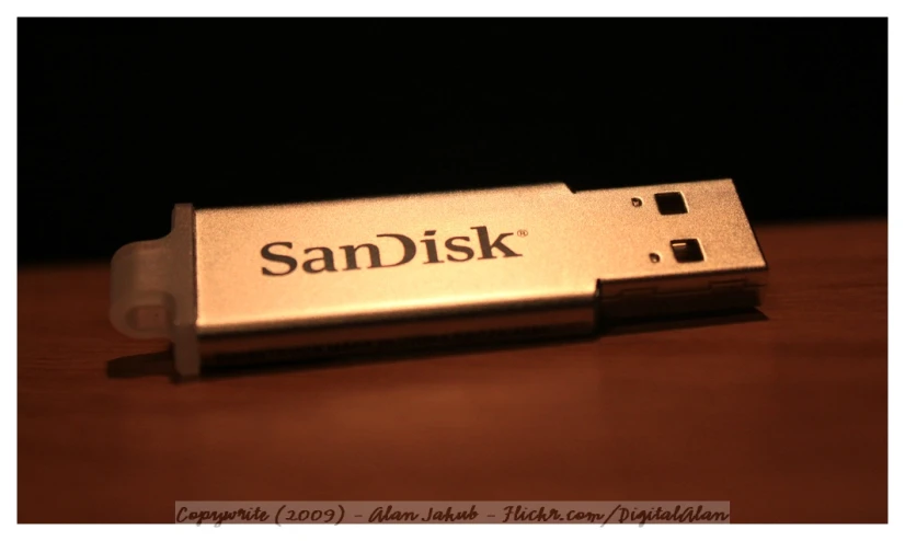 sandisk flash drive sitting on top of a wooden table