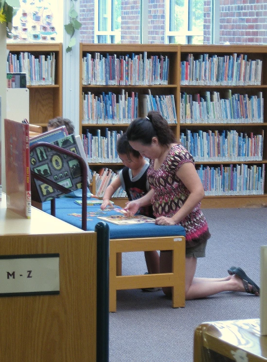 two children playing on the play table in a liry