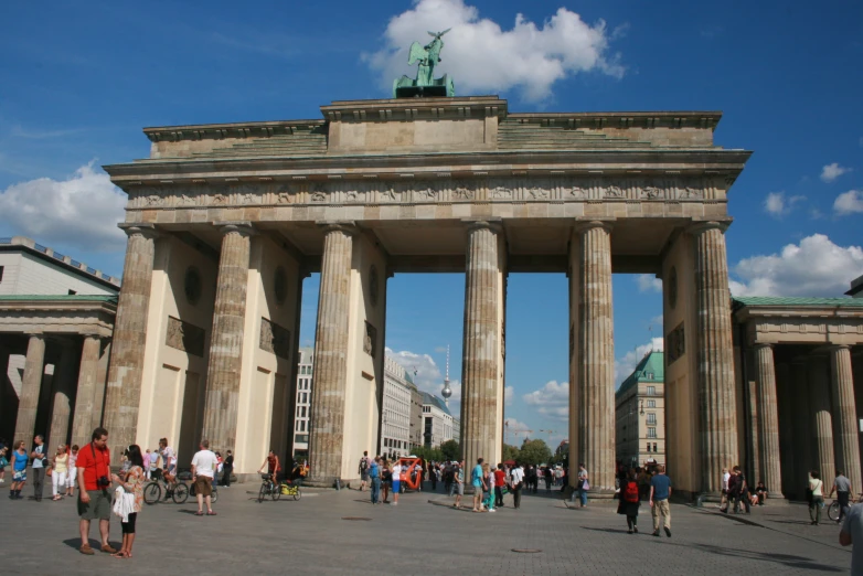 people are standing on the outside of an arch