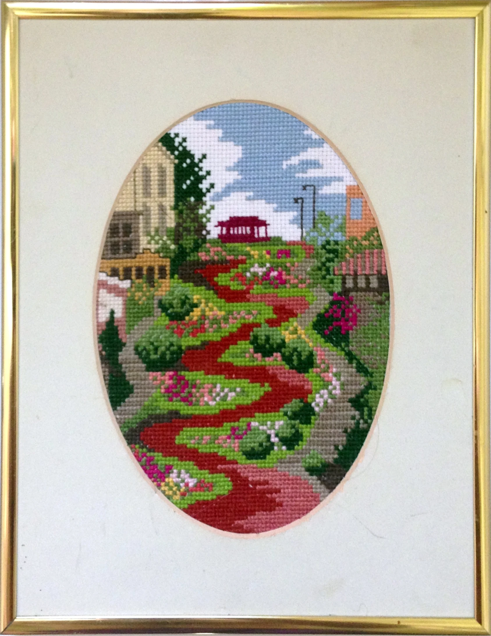 an embroidered picture with a garden and pathway