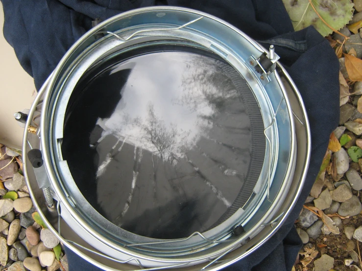 a glass dish with silver frame in a pile of rocks