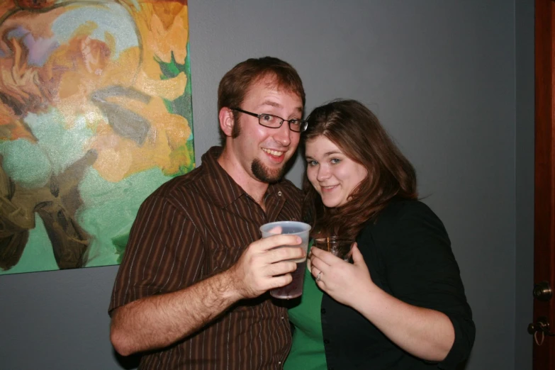 two people pose for the camera with wine