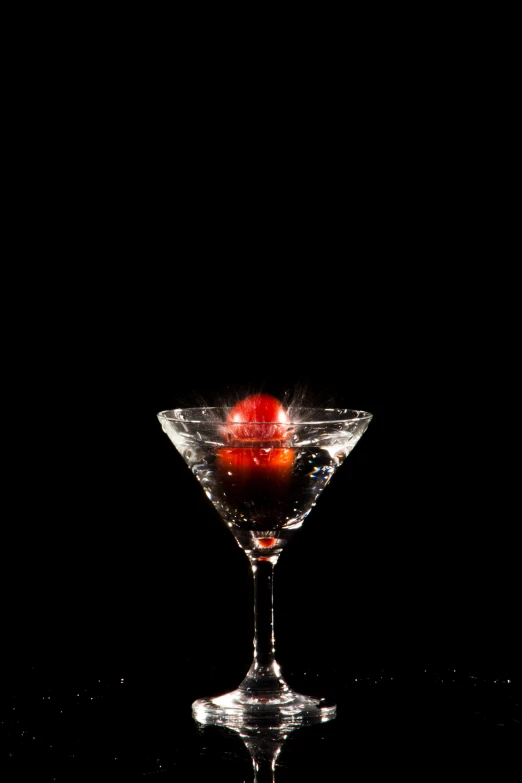 a cocktail glass with an apple inside on a table