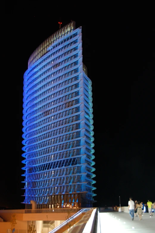 a large tall building with bright lights next to a walkway