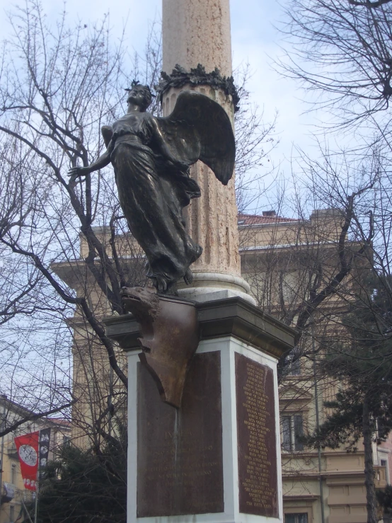 an old statue sits on the pedestal near the column