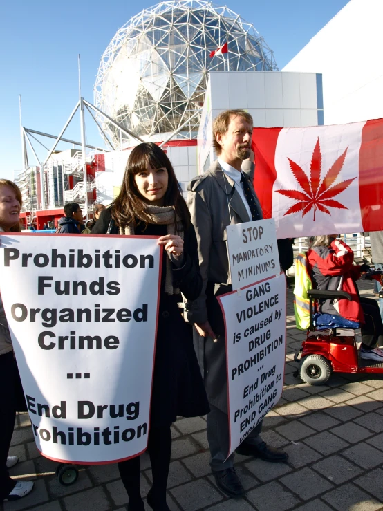 people holding signs with words and marijuana written on them