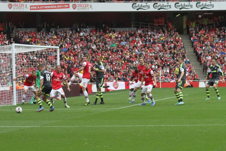 a soccer game in progress with the ball going towards the goal