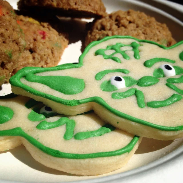 cookies decorated with green icing on a white plate