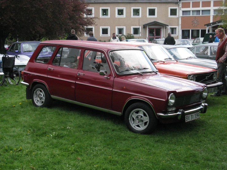 there is a red car parked at a show