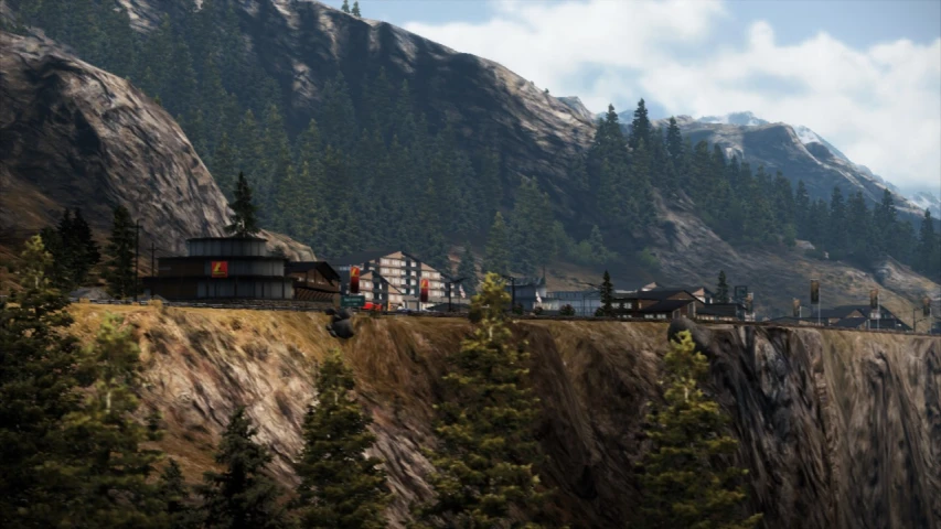 there is a train on the tracks passing a town with mountains in the background