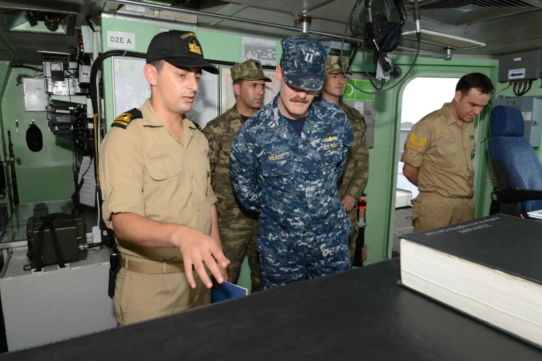 some soldiers are talking and standing near another uniformed person