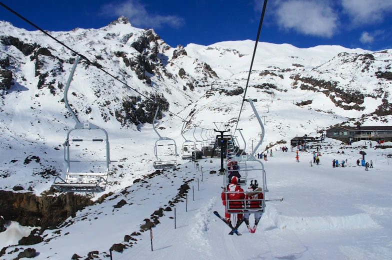 a person rides down the slopes on a ski lift