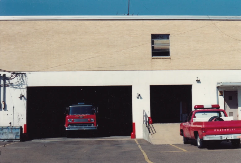 a red truck parked in front of a garage