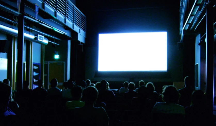 people in the audience watching a screen at night