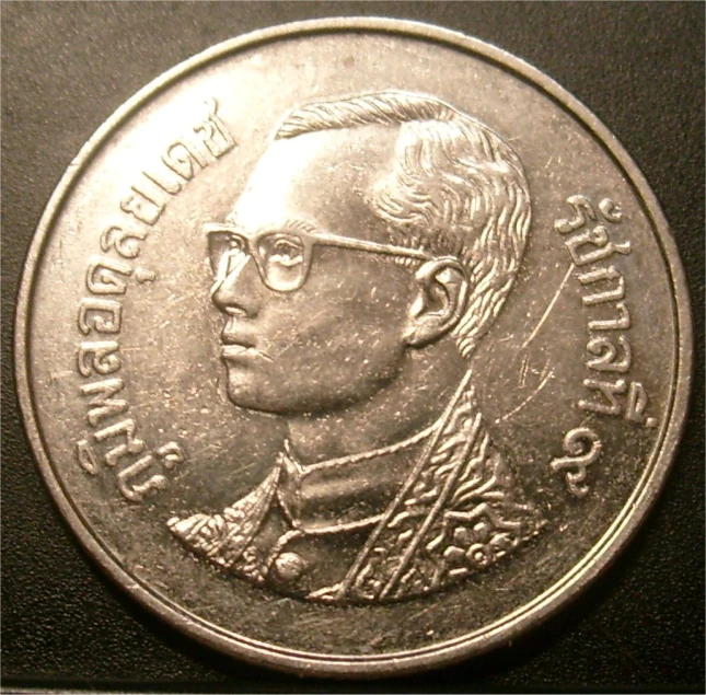 the coin is a portrait of a man wearing glasses