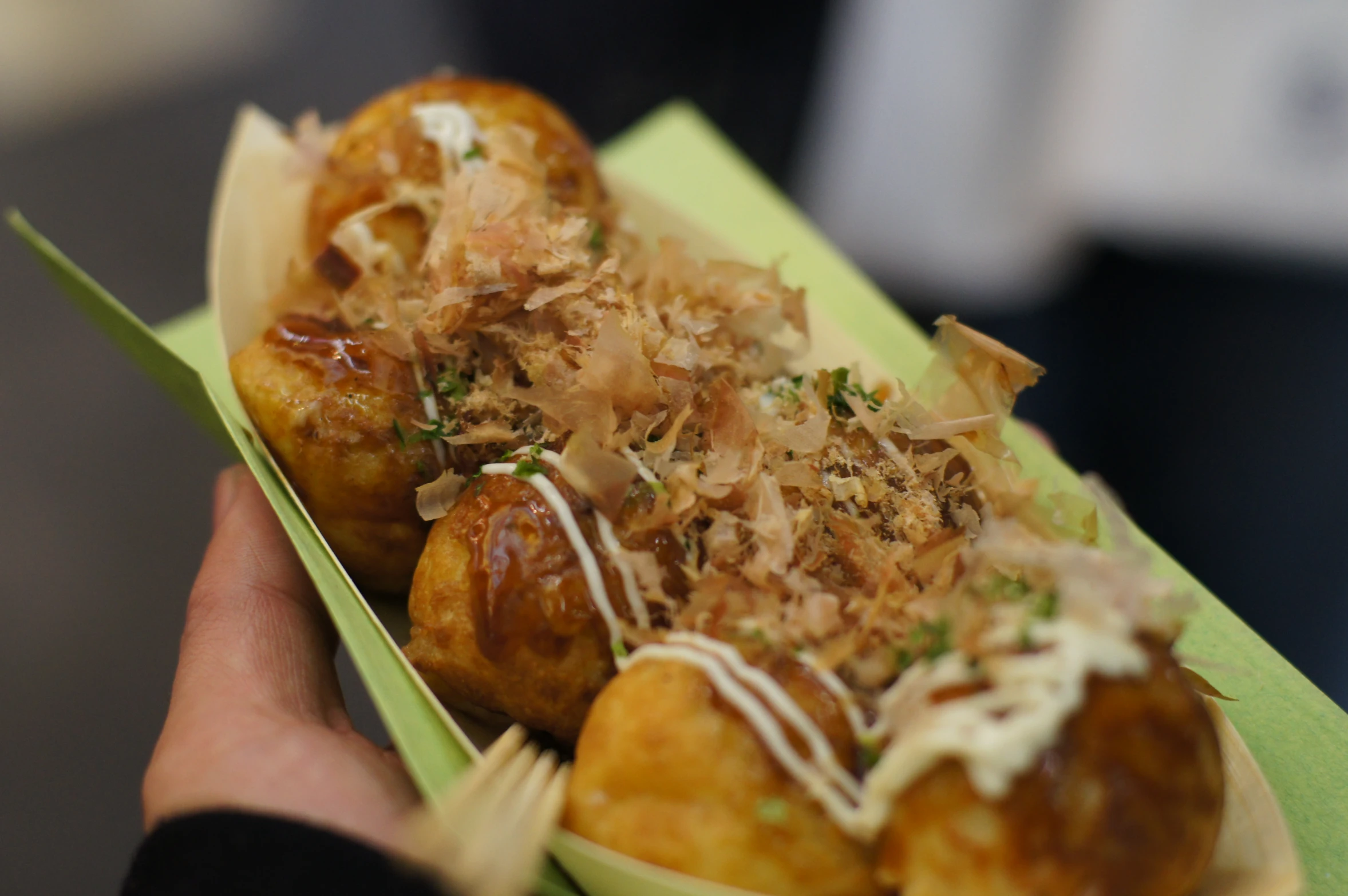 a person holding a box full of fried food