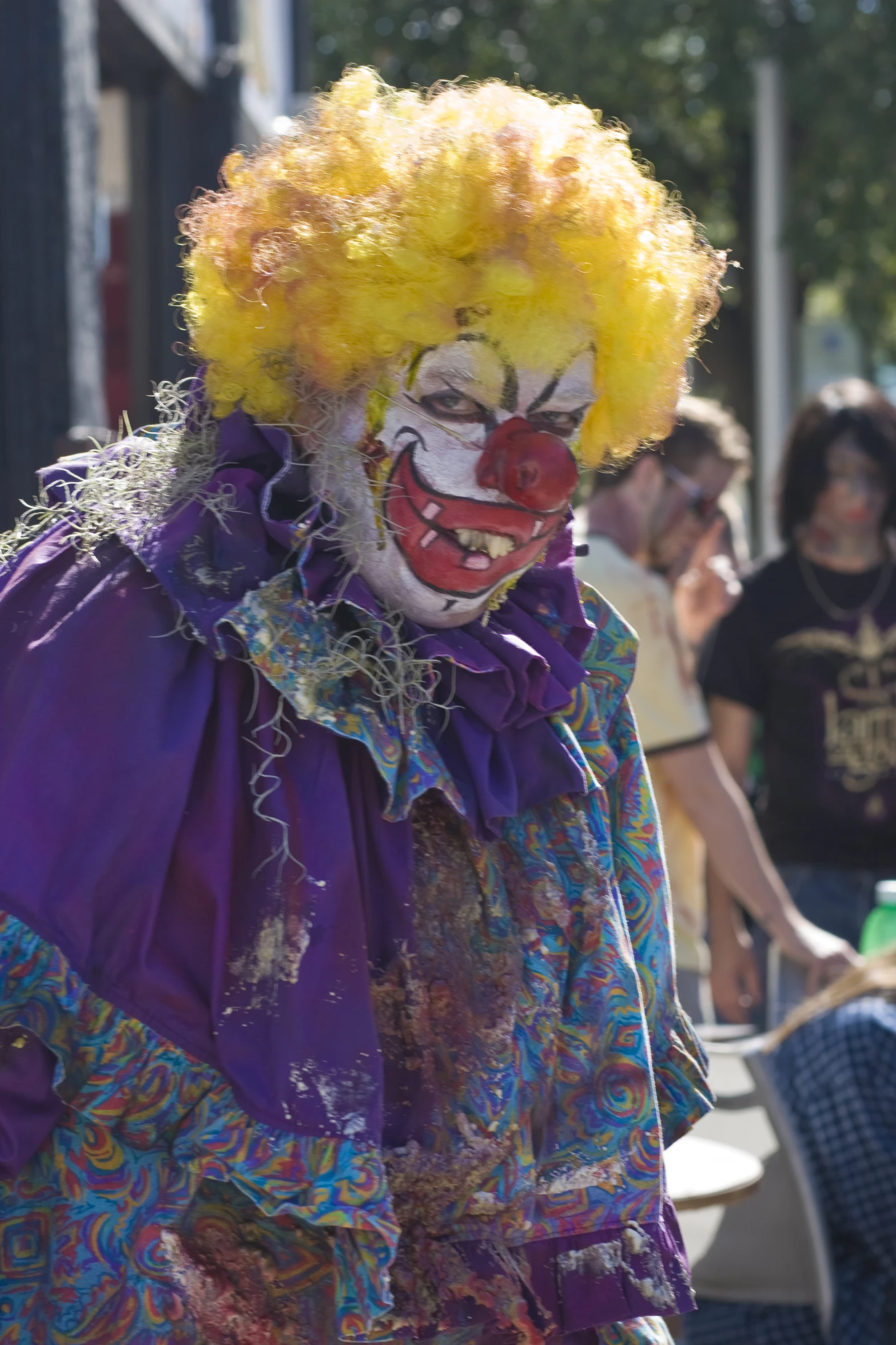 a clown with orange hair wearing purple clown makeup