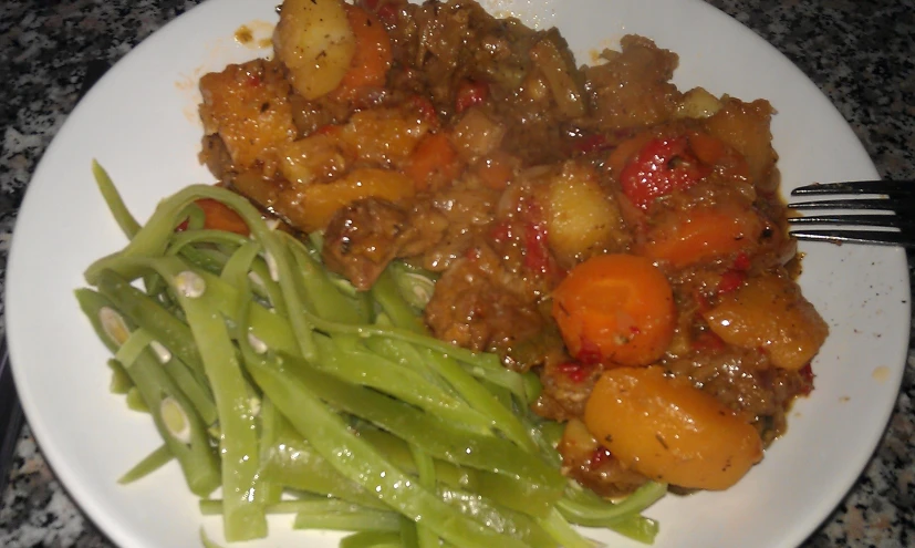 a plate filled with meat and green beans