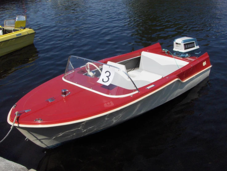 a motorboat docked at a harbor with two other boats