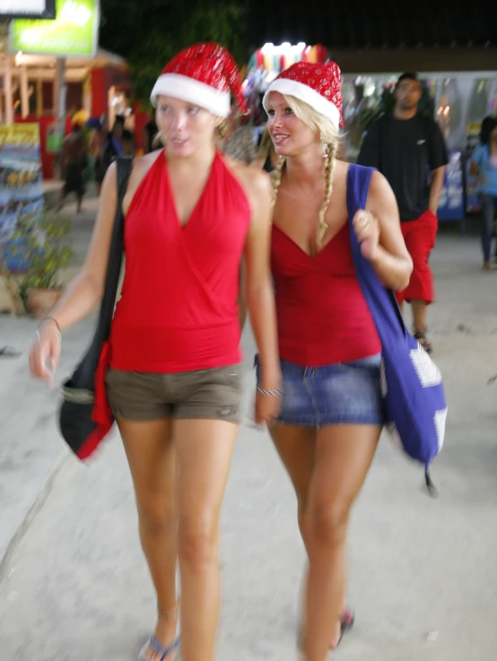 a couple of women walk together down a street