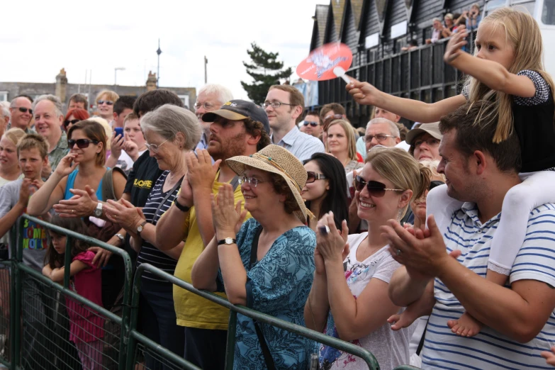 people watch as soing flies by in the air at a sporting event