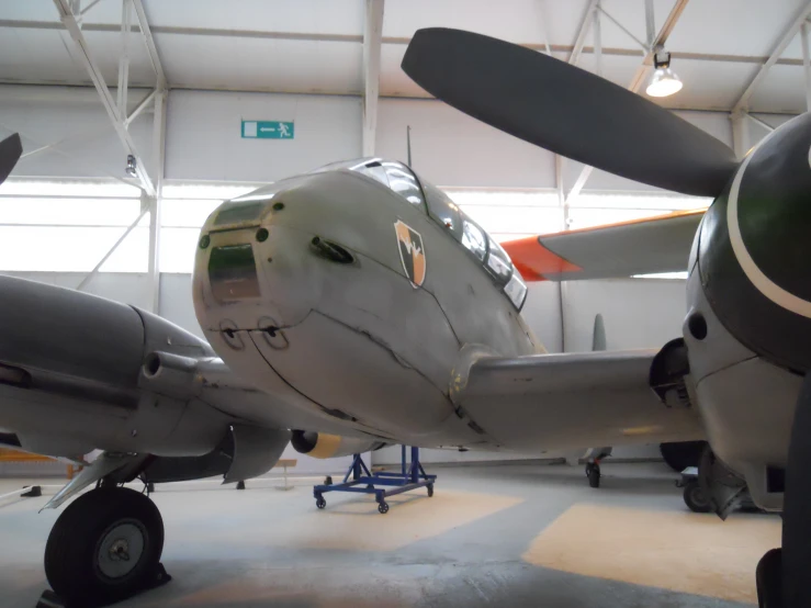 an old propeller plane on display in a hangar