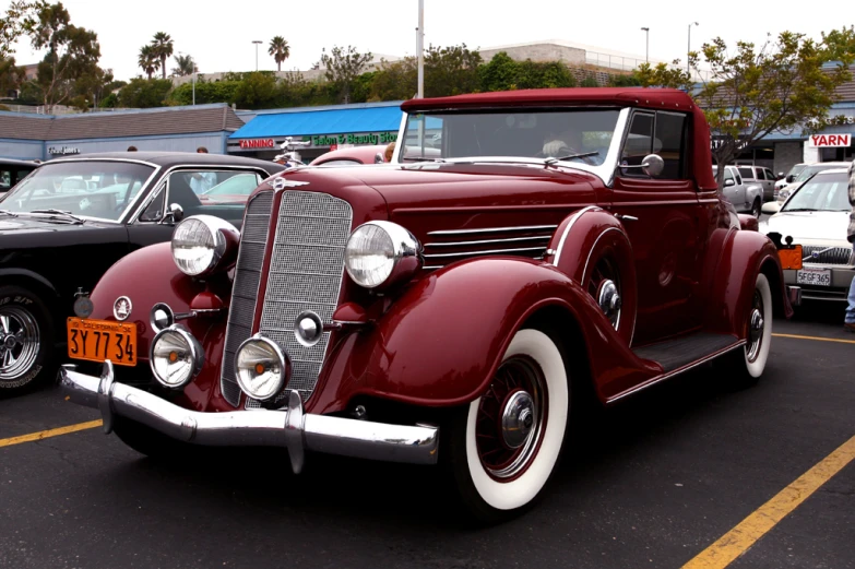 a vintage car with another antique car in the background