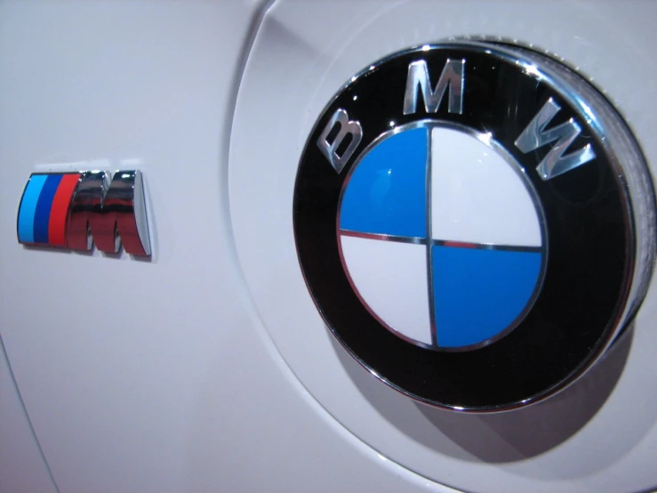 a white and blue bmw emblem and the word m & m in black on a white background