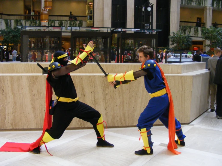 two people dressed in various poses one holding a sword