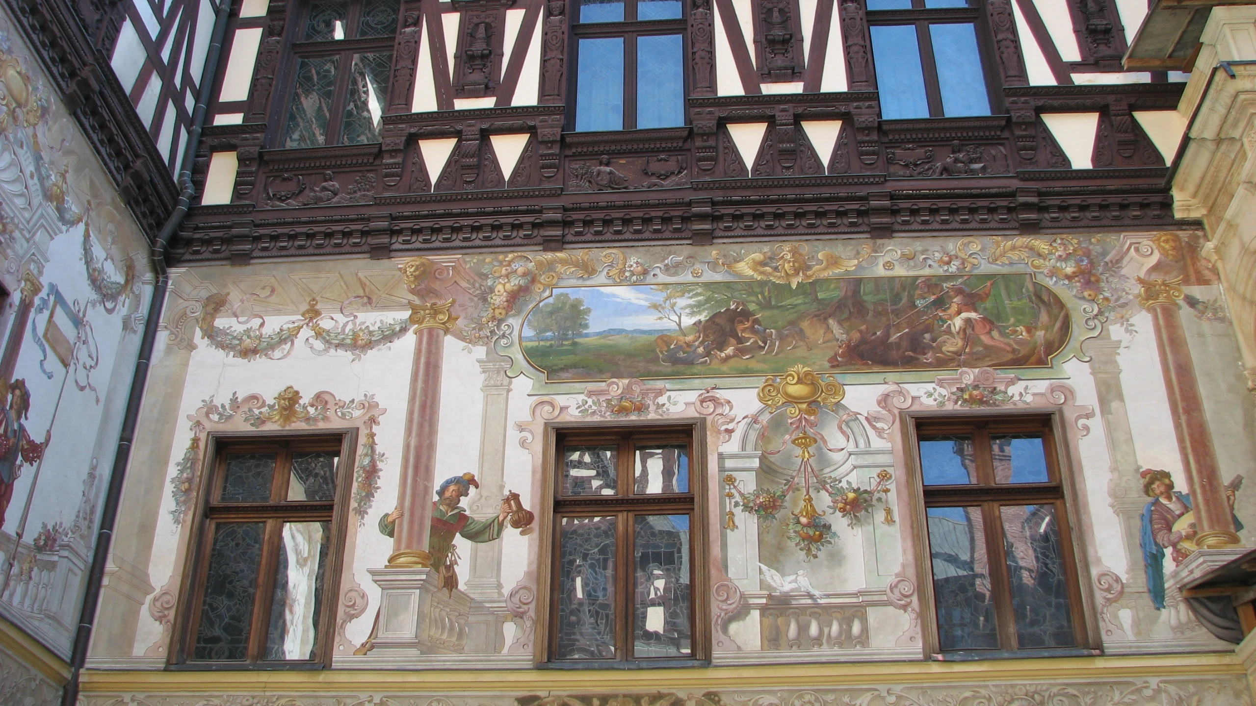 two ornate paintings with paintings on the side of a building