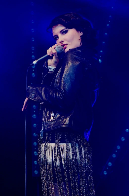 a woman in a black jacket holding a microphone