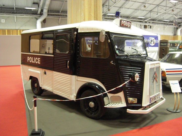 police car, in front of a white ambulance on display at an exhibit