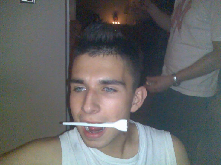 a man brushing his teeth with an electric toothbrush