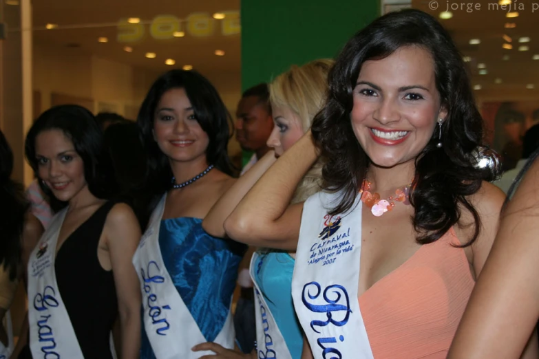 a group of women in dresses with necklaces on