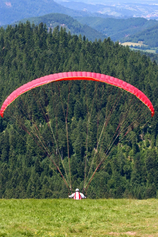 a person on top of a hill with red kite